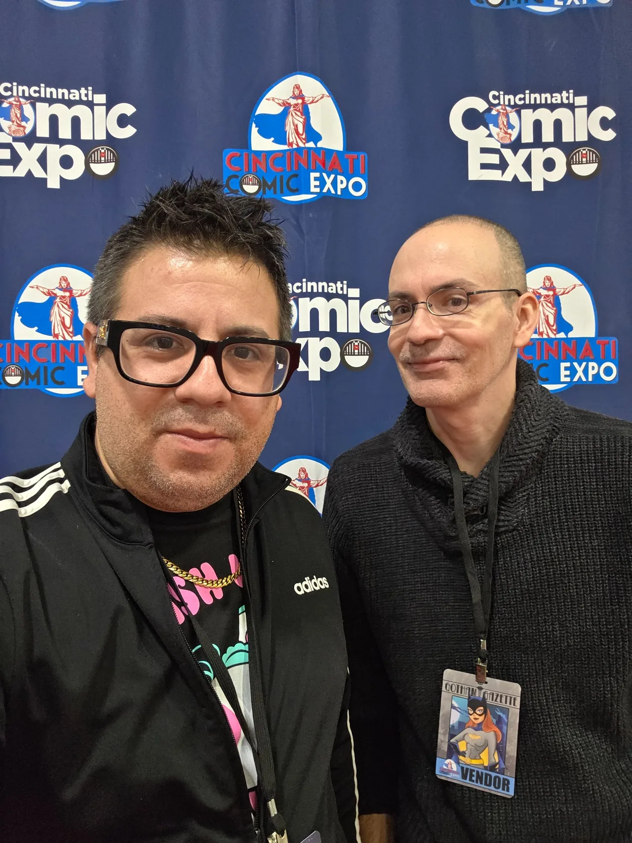Two attendees posing in front of the Cincinnati Comic Expo backdrop in 2026